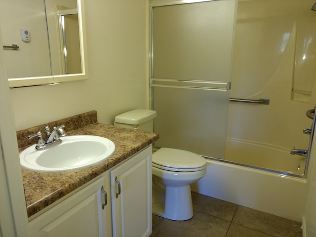 full bathroom with tile patterned flooring, vanity, combined bath / shower with glass door, and toilet