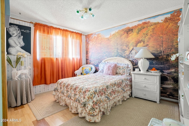 bedroom with light hardwood / wood-style floors and a textured ceiling