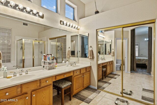 1943 E Drake Dr, Tempe, AZ 85283 - bathroom featuring tile patterned floors, double vanity, a shower stall, toilet, and a towering ceiling