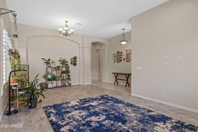1943 E Drake Dr, Tempe, AZ 85283 - foyer with arched walkways, wood finished floors, a chandelier, and baseboards