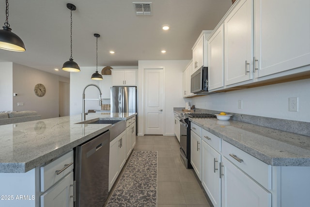 kitchen featuring white cabinetry, visible vents, appliances with stainless steel finishes, and pendant lighting