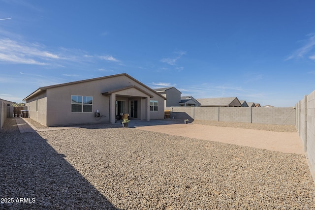 view of front of home with a patio area, a fenced backyard, and stucco siding