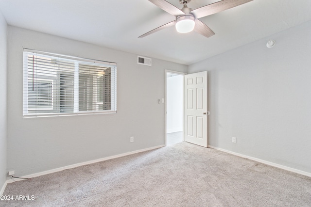 carpeted spare room featuring ceiling fan