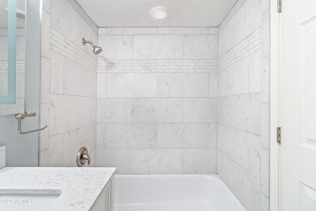 bathroom featuring vanity and tiled shower / bath