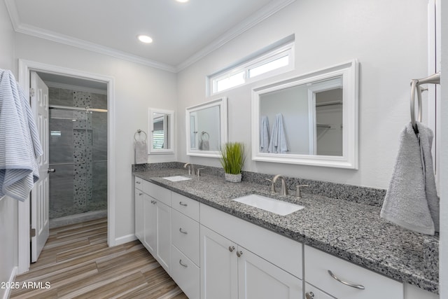 bathroom featuring an enclosed shower, ornamental molding, hardwood / wood-style floors, and vanity