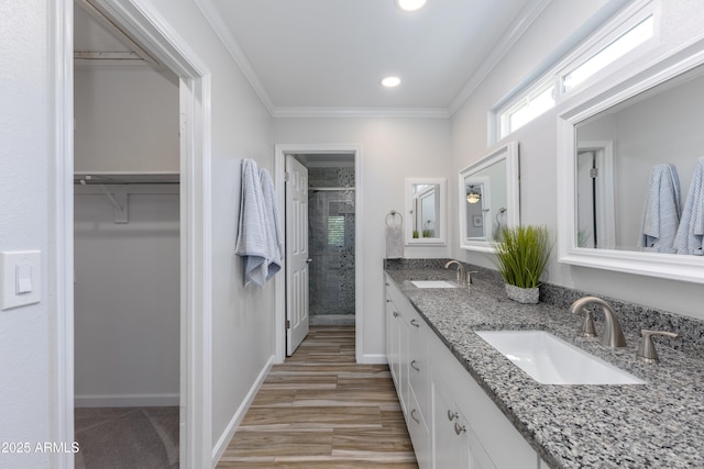 bathroom with crown molding, wood-type flooring, vanity, and walk in shower