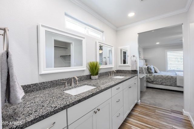 bathroom featuring ornamental molding, wood-type flooring, and vanity