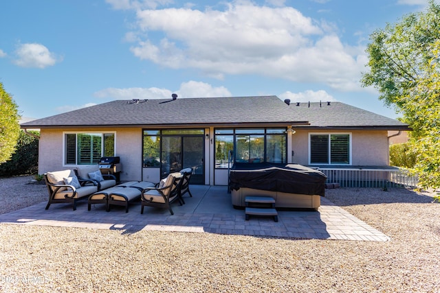 back of property with an outdoor living space, a hot tub, and a patio