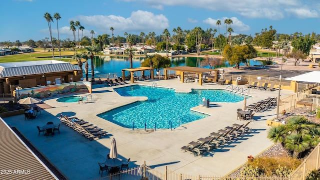 view of swimming pool with a patio, a water view, and a community hot tub