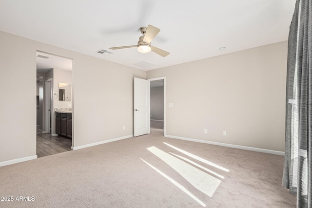 unfurnished bedroom featuring ceiling fan, light colored carpet, and ensuite bathroom