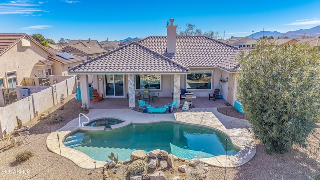 view of swimming pool with an in ground hot tub, a mountain view, and a patio