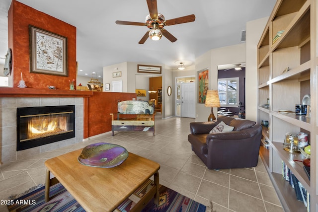 living room featuring tile patterned floors, a tile fireplace, and ceiling fan