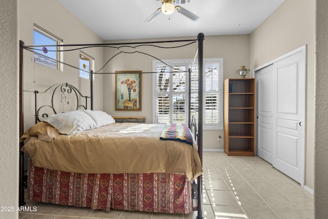 tiled bedroom with ceiling fan and a closet