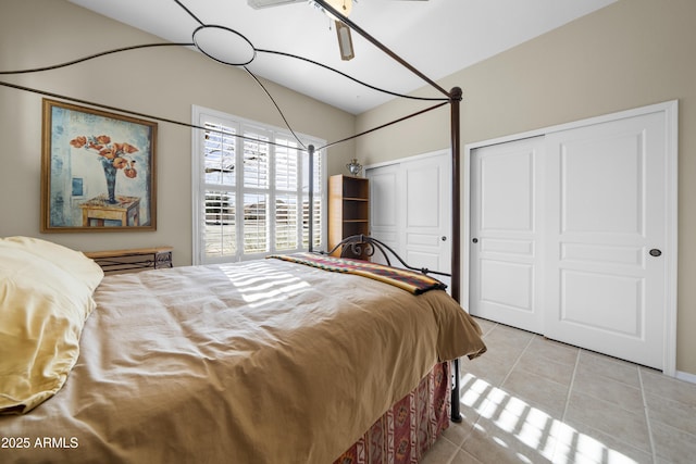 bedroom with light tile patterned flooring, ceiling fan, and multiple closets