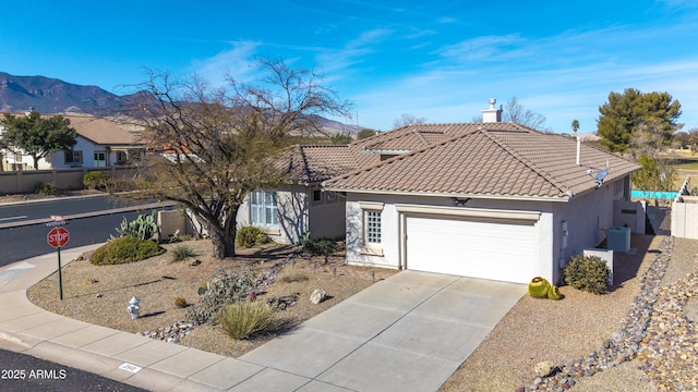 view of front facade featuring a garage, a mountain view, and central AC