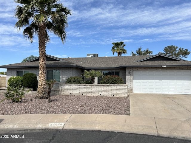 ranch-style home with an attached garage, driveway, and a shingled roof