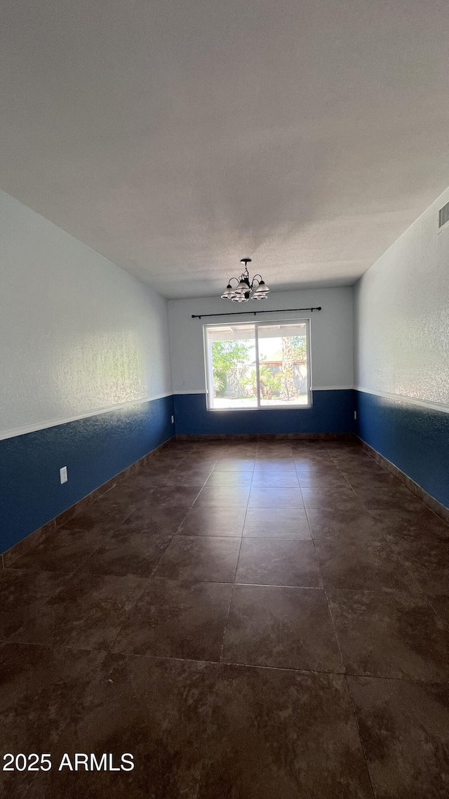 empty room featuring a chandelier