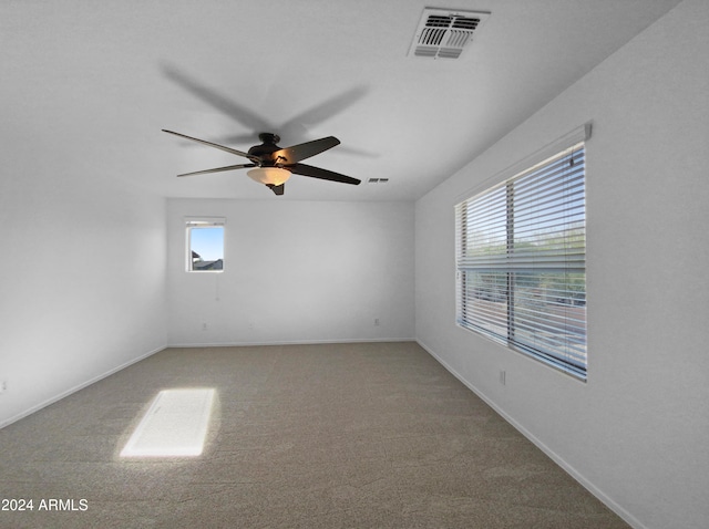 carpeted spare room featuring ceiling fan