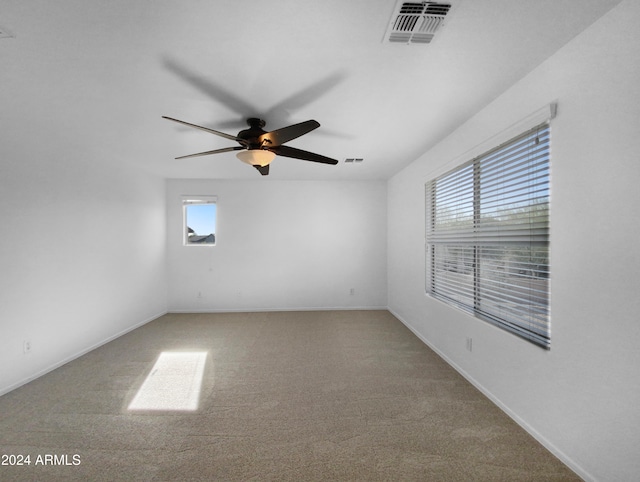 carpeted empty room featuring plenty of natural light and ceiling fan