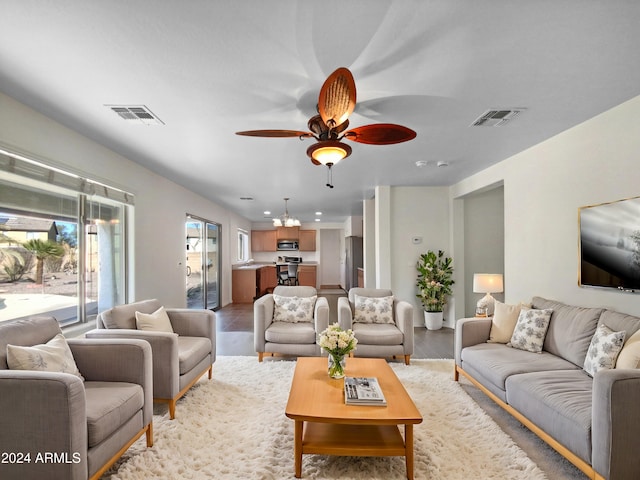 living room featuring light hardwood / wood-style flooring and ceiling fan with notable chandelier