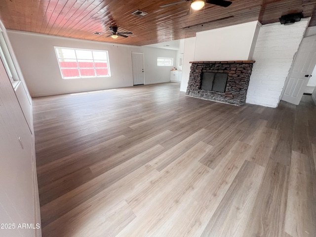 unfurnished living room featuring a fireplace, a ceiling fan, visible vents, wooden ceiling, and wood finished floors