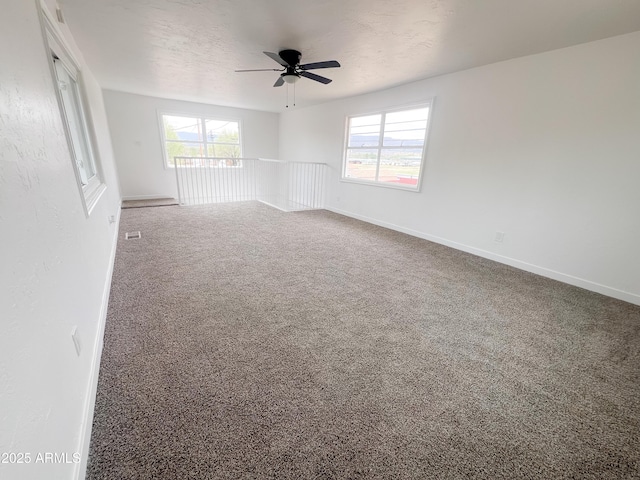 carpeted empty room with baseboards and ceiling fan