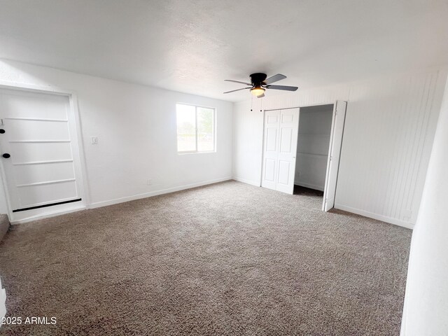 unfurnished bedroom featuring ceiling fan, a closet, carpet flooring, and baseboards