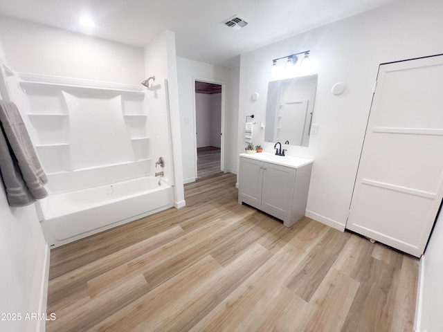 bathroom featuring bathing tub / shower combination, vanity, visible vents, wood finished floors, and baseboards