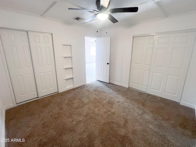 unfurnished bedroom featuring visible vents, baseboards, ceiling fan, crown molding, and carpet floors
