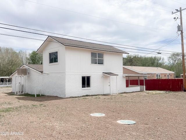 rear view of property featuring fence