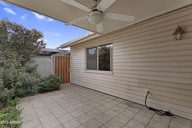 view of patio / terrace with a ceiling fan, a gate, and fence