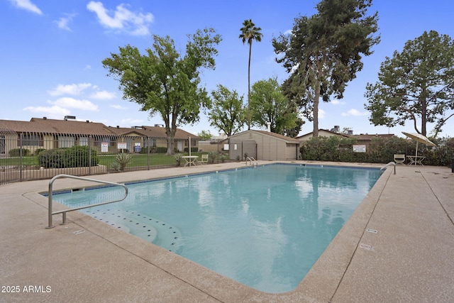 community pool featuring a residential view, a patio area, and fence