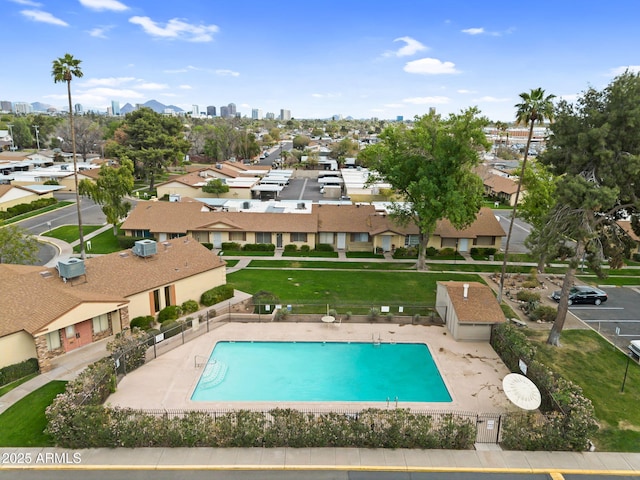 community pool with a yard, fence, and a patio