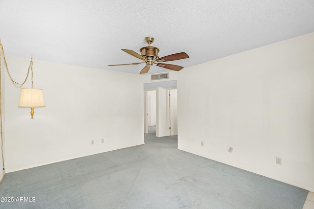 spare room featuring ceiling fan, a textured ceiling, visible vents, and carpet flooring