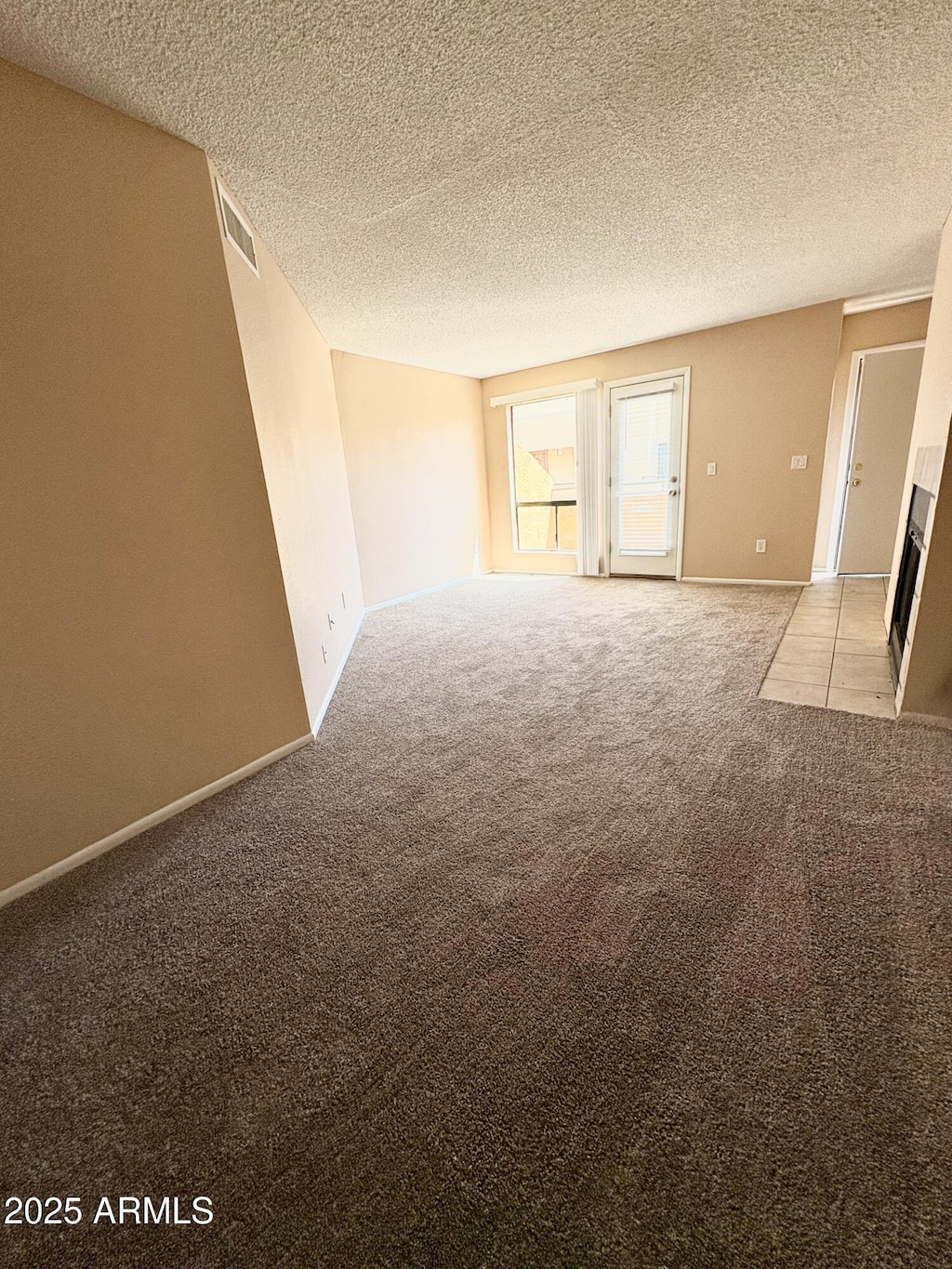 11640 N 51st Ave Unit 248, Glendale, AZ 85304 - unfurnished room featuring light colored carpet, a textured ceiling, baseboards, and visible vents