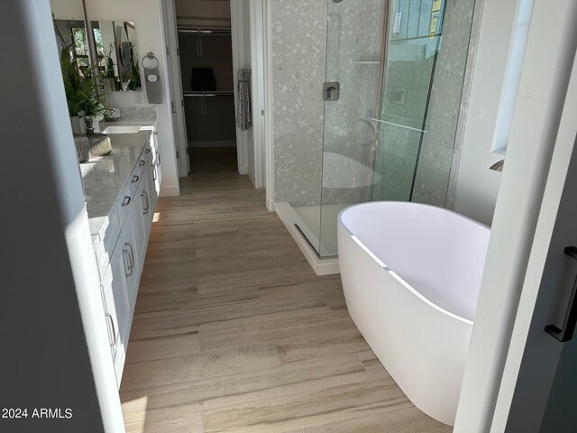 bathroom with shower with separate bathtub, vanity, and wood-type flooring