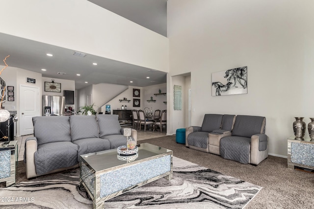 carpeted living room with a towering ceiling