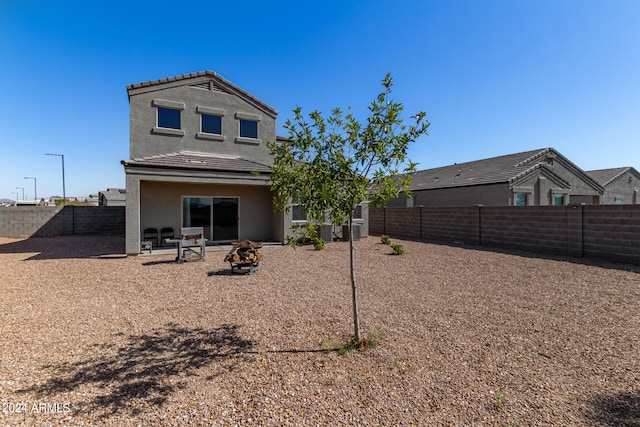 rear view of house featuring a patio and an outdoor fire pit