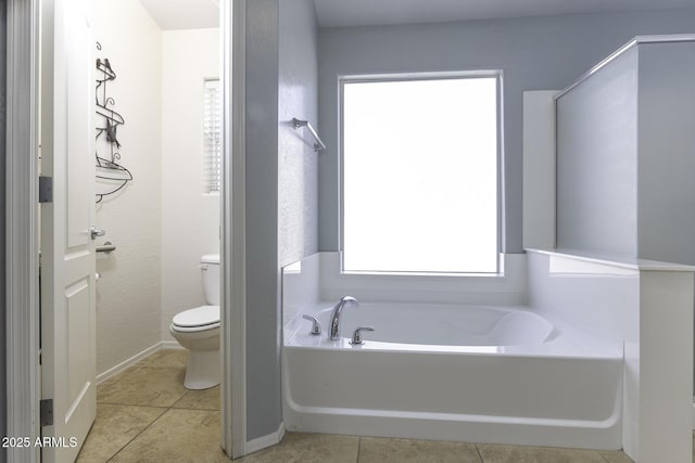 bathroom with a tub, toilet, and tile patterned flooring