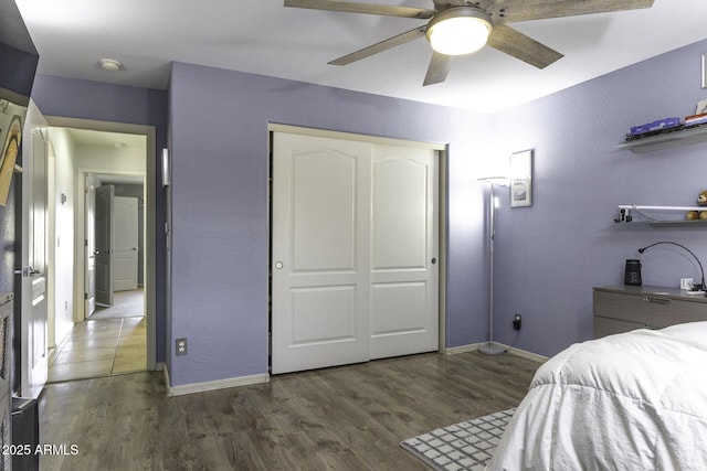 bedroom with ceiling fan, a closet, and dark hardwood / wood-style flooring