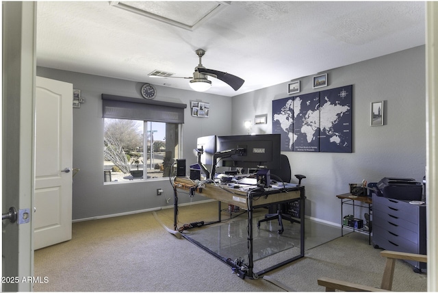 carpeted office space with visible vents, a ceiling fan, and baseboards