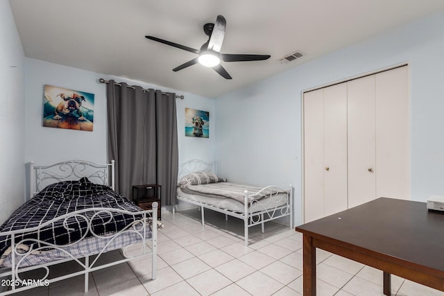 tiled bedroom featuring ceiling fan and a closet