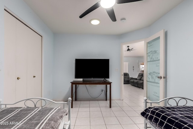 tiled bedroom with ceiling fan and a closet