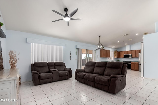 living room with lofted ceiling, light tile patterned floors, and ceiling fan