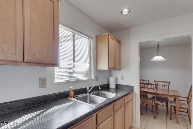 kitchen featuring plenty of natural light, light brown cabinets, hanging light fixtures, and sink