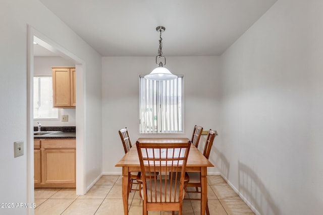 dining room featuring sink, light tile patterned floors, and plenty of natural light