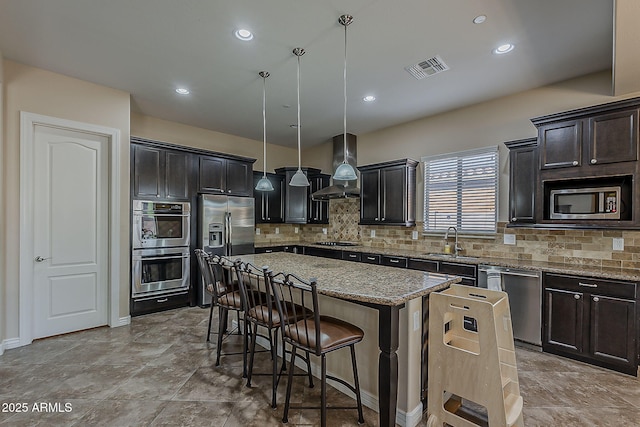 3925 E Elmwood St, Mesa, AZ 85205 - kitchen with stainless steel appliances, a kitchen breakfast bar, a kitchen island, light stone counters, and tasteful backsplash