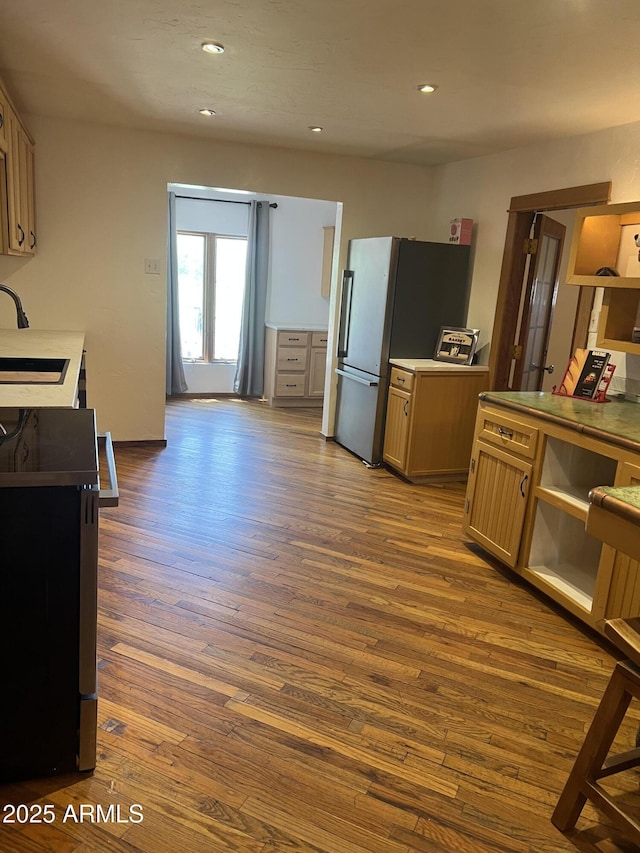 kitchen with freestanding refrigerator, recessed lighting, dark wood-style flooring, and a sink