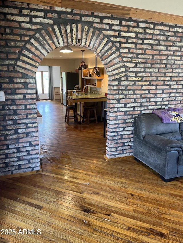 interior space with arched walkways and hardwood / wood-style flooring