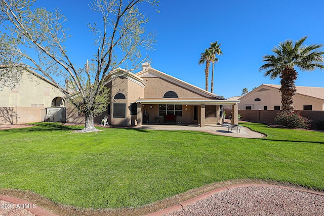 rear view of house featuring a yard, a patio area, and fence